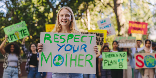 istock Happy youth activist leading a march against climate change 1477815547