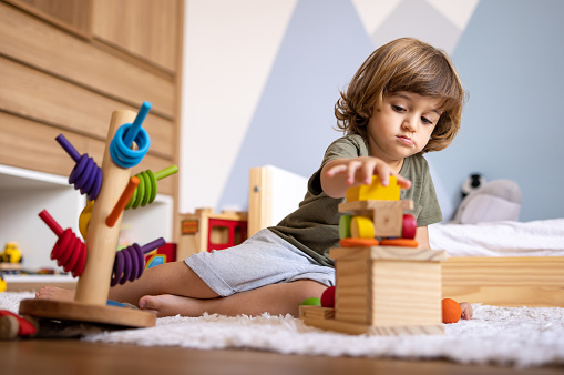 Brazilian boy learning while playing at home with toys - childhood lifestyle concepts
