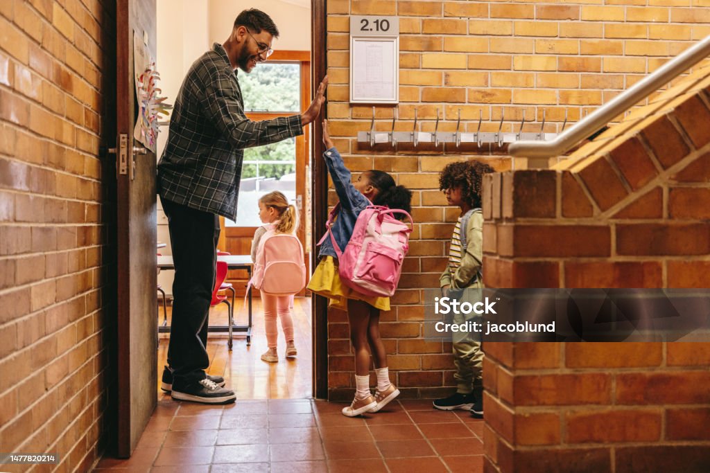 Giáo viên tiểu học chào đón học sinh của mình ở cửa. Nam giáo viên chào đón lớp học với điểm cao - Trả phí Bản quyền Một lần Giáo viên Bức ảnh sẵn có Giáo viên tiểu học chào đón học sinh của mình ở cửa. Nam giáo viên chào đón lớp học với điểm cao - Trả phí Bản quyền Một lần Giáo viên Bức ảnh sẵn có