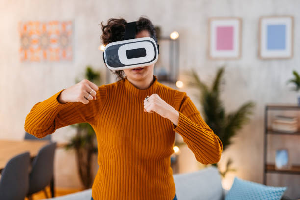 istock Young Woman Playing A Boxing Game On A Virtual Reality Headset At Home 1477820381