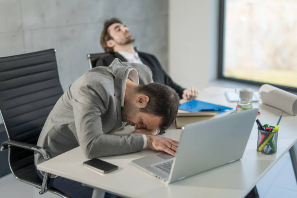 istock Two exhausted businessmen sleeping in the office. 1477820489
