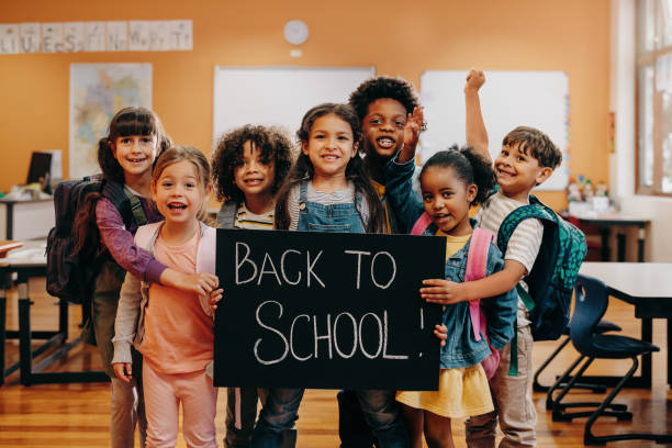 back to school celebration. excited elementary school class ready to learn - yeni öğretim yılı stok fotoğraflar ve resimler