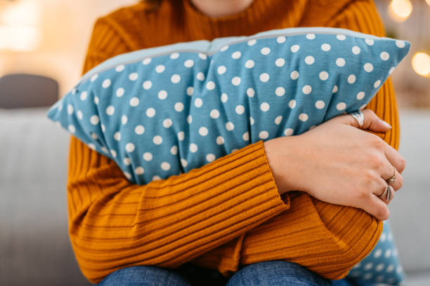 Young Woman Hugging A Pillow At Home At Night