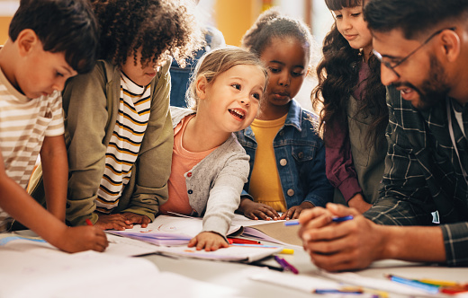 A girl with down syndrome is in a classroom with her teacher