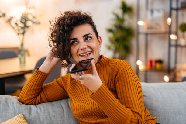 istock Young Woman Sending A Voice Message At Home 1477821772