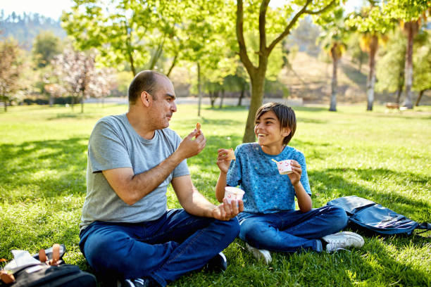 istock Smiling man and young boy enjoying ice cream cones 1477824216