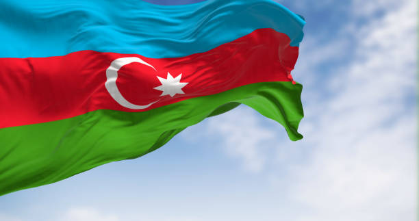 die nationalflagge von aserbaidschan weht an einem klaren tag im wind. - azerbaijan flag stock-fotos und bilder