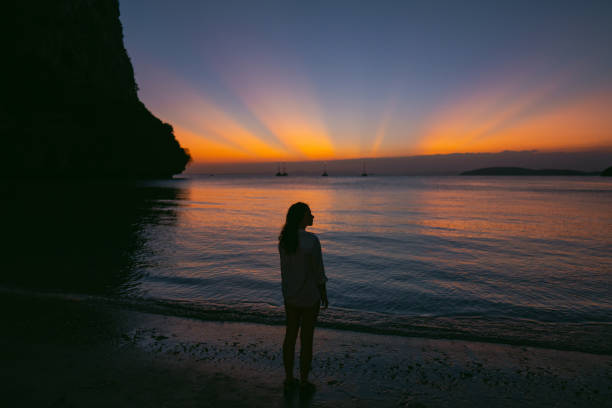 Woman looking at unusual vibrant sunset over the sea