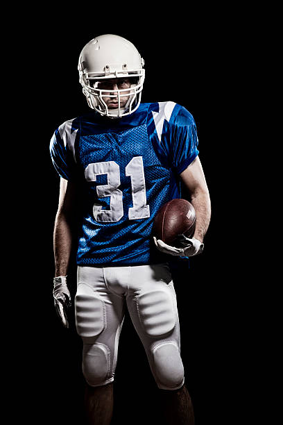Football Player with number Football Player with number on the uniform and a ball in the hand. Studio shot. american football player studio stock pictures, royalty-free photos & images