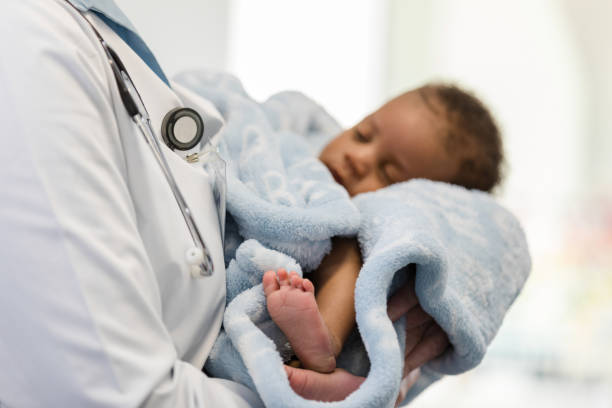 istock Trusting newborn sleeps in unrecognizable doctor's arms 1477833220