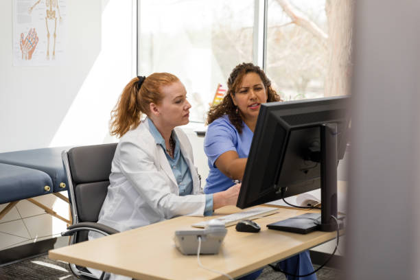 istock Searching internet on desktop PC, nurse has question for doctor 1477833250