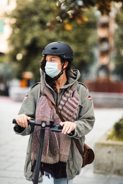 istock woman portrait on the scooter with face mask 1477833366