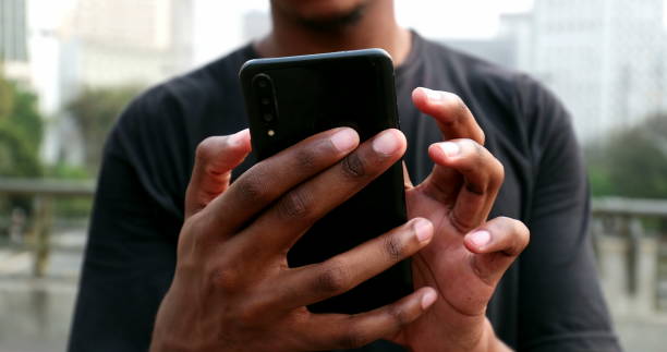 istock African black man using cellphone in street 1477836324