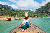 Cheerful woman traveling with Thai taxi boat
