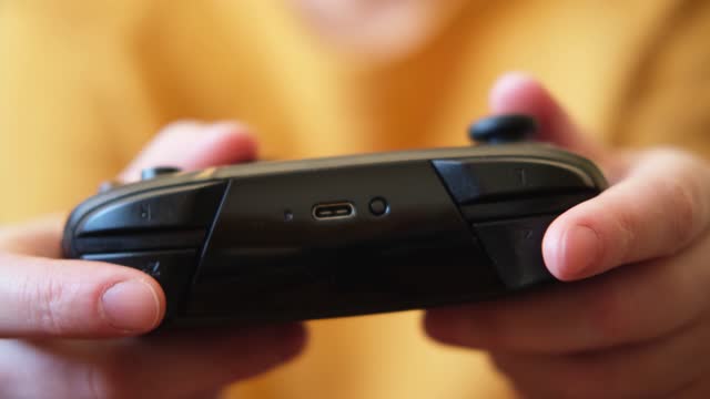 Woman hands holding black joystick gamepad playing game console. Computer gaming competition videogame control concept. Using controller playing video games. Cyberspace symbol. Hands joypad close up.