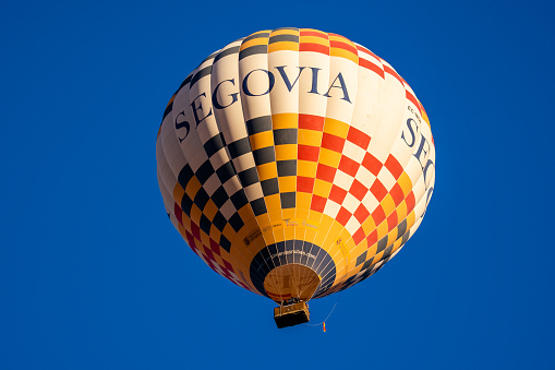 Segovia, Spain - February 5, 2023: Colorful hot-air balloons against blue sky