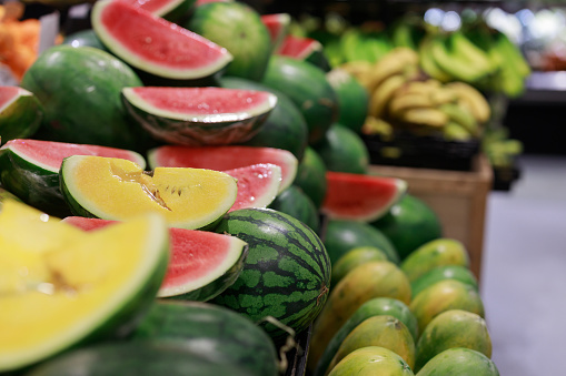 Summer tropical fruits, watermelon, papaya and banana display on shelf in a grocery store