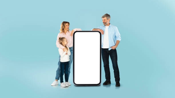 istock Family Leaning On Mobile Phone With Empty Screen, Blue Background 1477838586