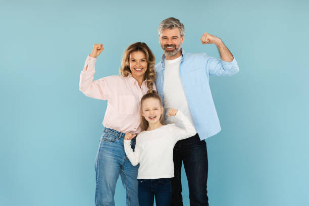 istock Cheerful Family Showing Biceps Muscles On Blue Background 1477838591