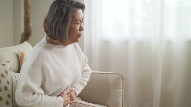 Senior woman waking up suffering for stomachache