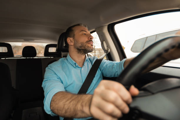 istock Confident man driving new car in city 1477841104