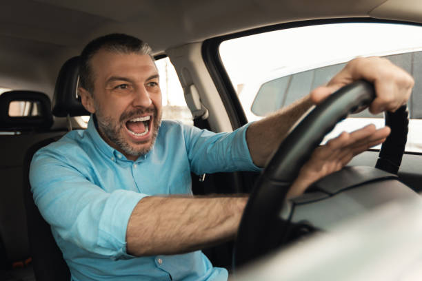istock Angry man driving car shouting and honking 1477841106