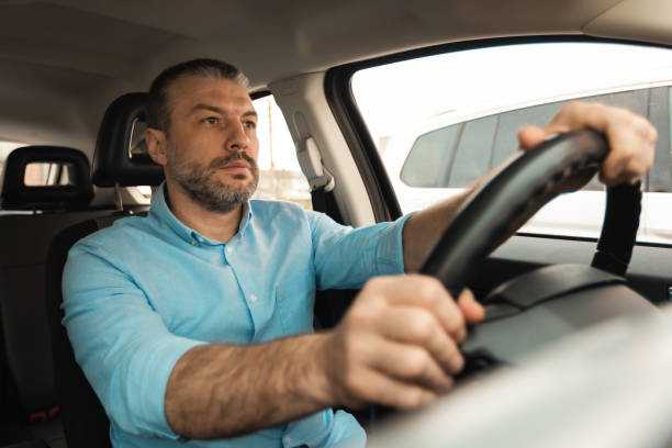 istock Confident man driving new car in city 1477841110