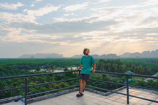 Horizontal view of man isolated at home with a view from the window of the blue ocean on the background.