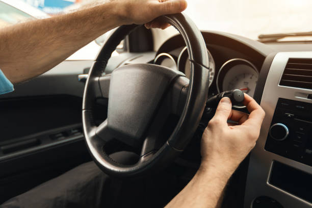 istock Man driving new car in city, turning on windshield wipers 1477841366