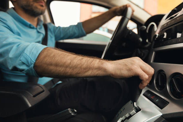 istock Unrecognizable man driving new car in city 1477841375