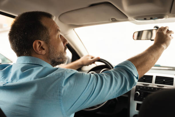 istock Male Adjusting Rear View Mirror Sitting In Seat Driving Car 1477841387