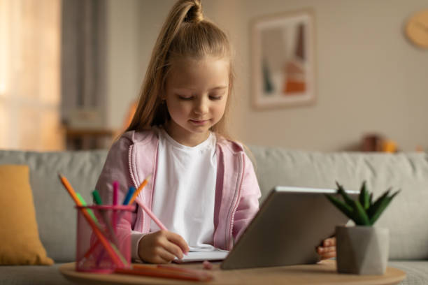istock School Kid Girl Using Digital Tablet Doing Homework Online Indoor 1477841460