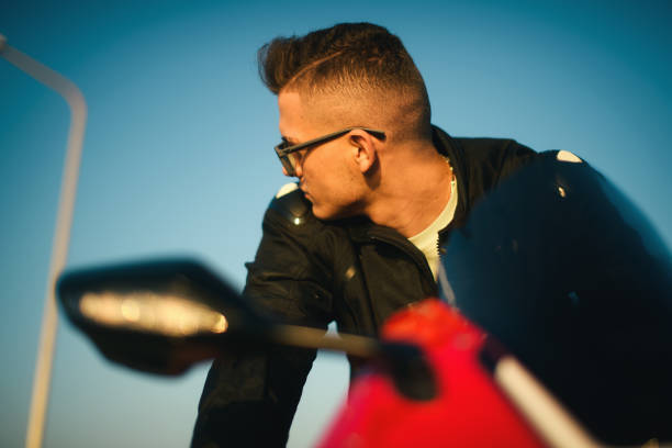 portrait of a young man with sunglasses on a red race motorbike. - motorsprot imagens e fotografias de stock