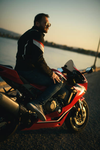 赤いレースバイクにサングラスをかけた男性のポートレート。 - motorsprot ストックフォトと画像