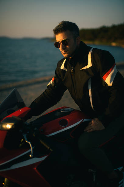 赤いレースバイクにサングラスをかけた男性のポートレート。 - motorsprot ストックフォトと画像