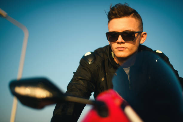 portrait of a young man with sunglasses on a red race motorbike. - motorsprot imagens e fotografias de stock