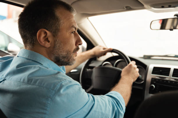 istock Male Driver Driving Sitting In Automobile, Back View 1477841670