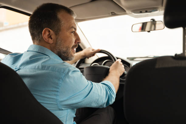 istock Middle Aged Man Driving Sitting In New Auto, Rear View 1477841675