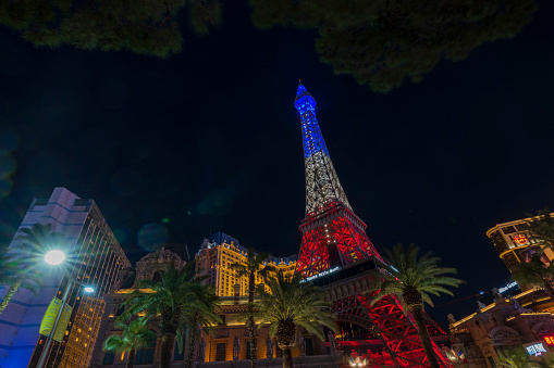 Las Vegas, Nevada, USA. 09.16.2022. Gorgeous night view of tops of Strip's hotel buildings, with luminous blue-white-red light of Eiffel Tower.
