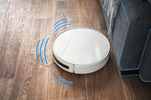 Robot vacuum cleaner performs automatic cleaning of the apartment. Smart home concept