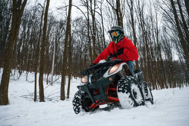 istock Snow, trees, adventure. Man is riding ATV outdoors in the winter forest 1477842953