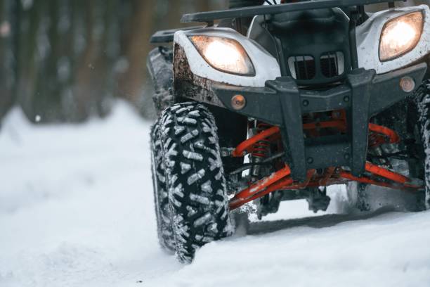 istock Snow, trees, adventure. Man is riding ATV outdoors in the winter forest 1477843071