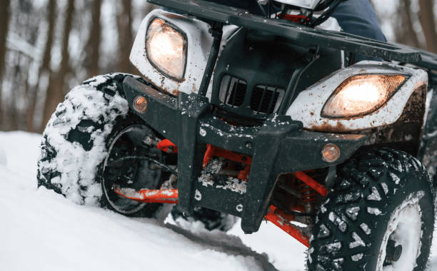 istock Snow, trees, adventure. Man is riding ATV outdoors in the winter forest 1477843869