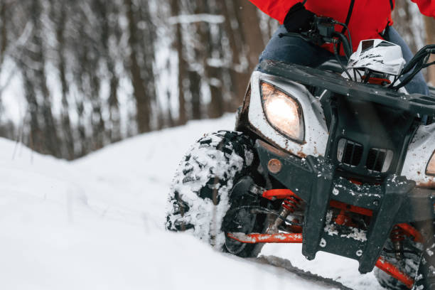 istock Man is riding ATV outdoors in the winter forest 1477843871