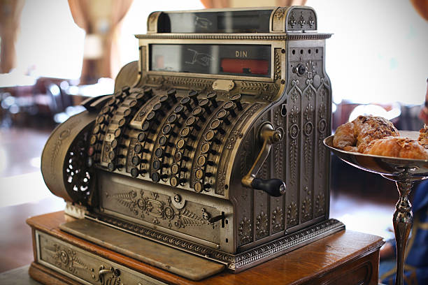 Antique cash register placed next to pastries on a stand stock photo