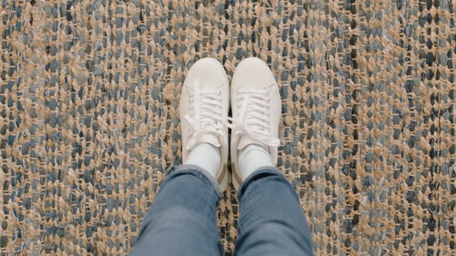 top view woman wearing white shoes enjoying stylish new footware standing on carpet rug