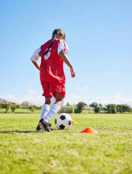 Sports, training and girl playing soccer for fitness, physical activity and hobby on a field in Spain. Active, focus and athlete dribbling a football for a game, cardio and match on the grass