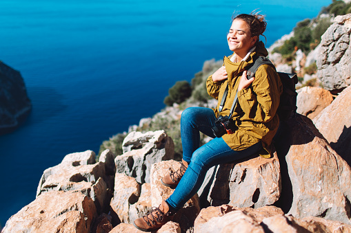 Young adult woman looking at Butterfly valley and enjoying the view, Mugla, Fethiye, Turkey