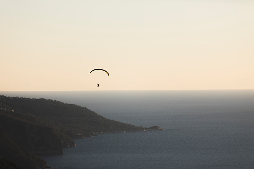 Silhouette of paraglider against the sky during sunset