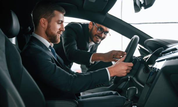 istock Man showing automobile interior to the customer 1477846453
